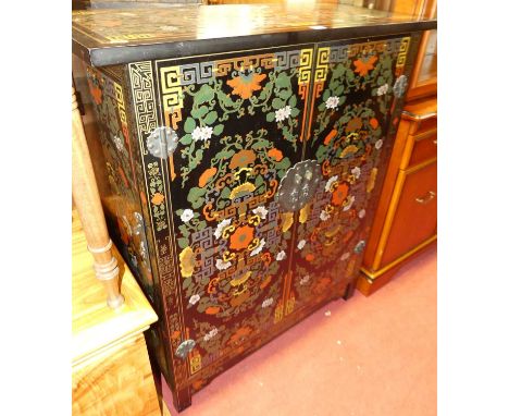 A contemporary Oriental black lacquered and floral polychrome painted double door drinks cabinet, having a hinged upper surfa