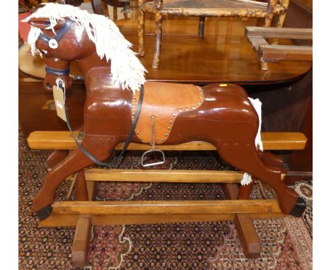 A child's painted carved wood rocking horse, on oak base length 112cm