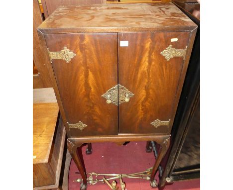 A figured walnut and floral pierced brass mounted double door drinks cabinet, raised on shell capped elongated cabriole suppo