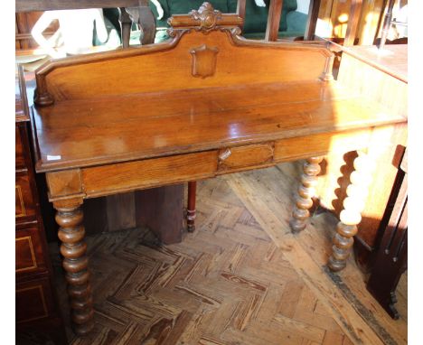 A late Victorian oak two drawer table with upstand and bobbin legs