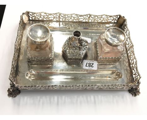 A Victorian silver standish with pierced decoration and gadrooned edges resting on pad feet, two pen wells, two glass and sil