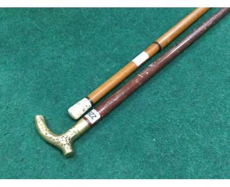 A late 19th century Malacca walking cane with Inuit style decorated ivory knop, together with a brass handled walking stick.