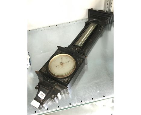 An early 20th century Negretti & Zambra carved oak cased barometer and thermometer with silvered metal dials in the aesthetic