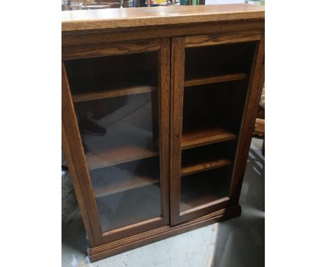 20th Century Oak bookcase, adjustable shelves, enclosed with glazed doors, plinth base (7cm x 122cm x 30cm) 