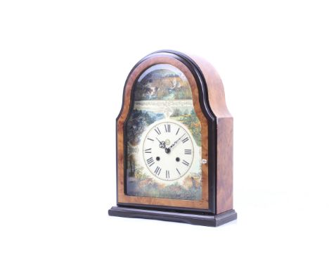 A contemporary 8 day mantel clock with rural scene dial. Striking to a bell, with a printed dial, Roman numerals and scenes o