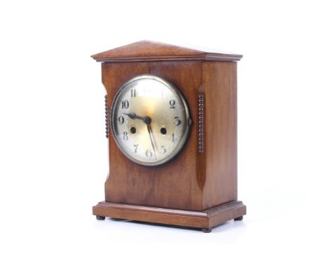 A 20th century mahogany cased mantel clock. 8 day striking movement. Arabic numerals on a silvered dial. Striking to a gong. 