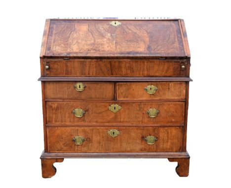 George II walnut bureau, fall flap enclosing well, pigeon holes, cupboard and drawers, over two short and two long drawers on