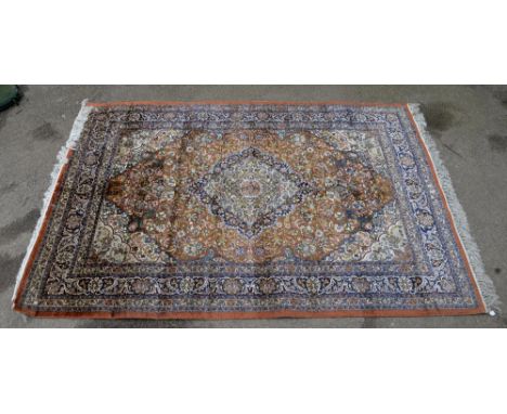 Persian silk burnt-orange ground carpet, with a main blue border, centre of which has concentric lozenges, 270 x 188 cm.     