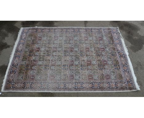 Persian silk  cream ground carpet, with a main blue border, the centre with repeating rectangular medallions, part-silk, 280 