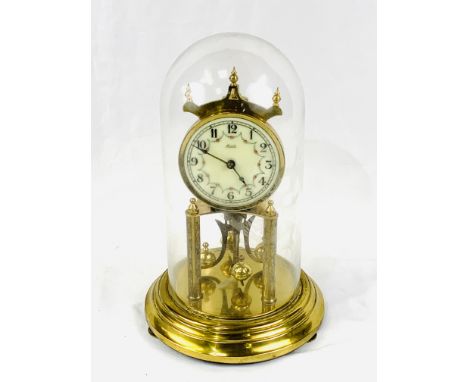 Brass anniversary clock under a glass dome, by Kieninger &amp; Obergfell, overall height 32 cms. Estimate £30-50