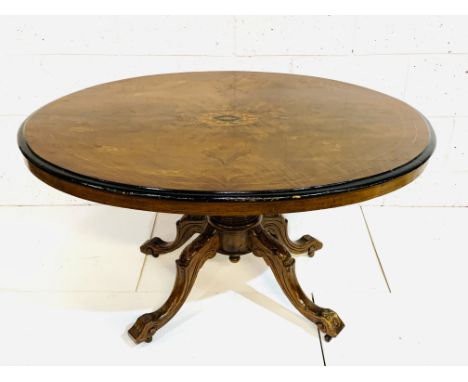 Mahogany oval tilt top tea table with flame mahogany veneer and inlay to top, on pedestal to four carved legs on casters, 127