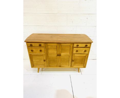Ercol style sideboard with centre cupboard flanked by two drawers with cupboards below, on splayed legs, 131 x 50 x 85cms. Es