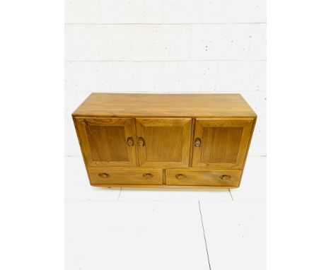 Ercol sideboard of three cupboards over two drawers, on casters, 130 x 45 x 76cms. Estimate £100-120.