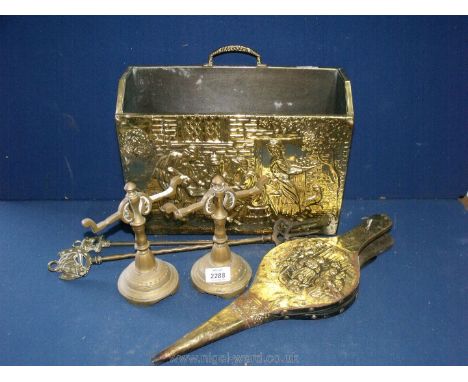 A brass magazine rack, bellows, two pokers and two fire dogs.
