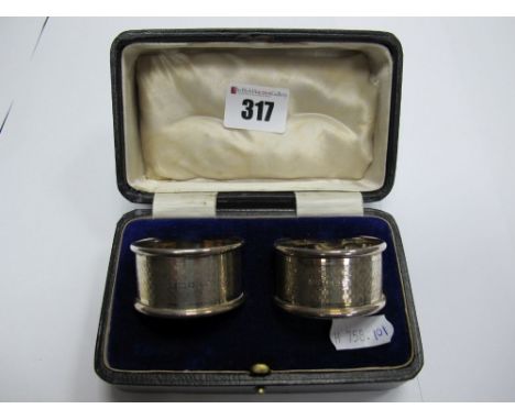 A Pair of Hallmarked Silver Napkin Rings, engine turned, contained in a fitted case. 