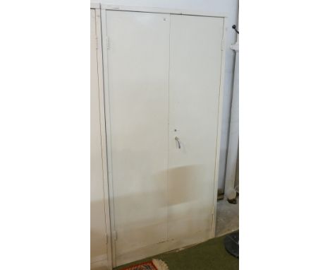 White painted metal workshop double cabinet with one interior shelf, measuring 183cm high, 91cm wide, 46cm deep.