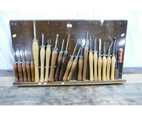 Wooden rack of wood turning chisels which include spindle gouges, bowl gouges, parting chisel etc by Robert Sorby, Axminster 