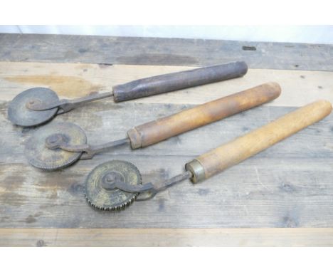 Three vintage leather workers tools, each with embossed brass wheel and turned handle, length approx 46cm.
