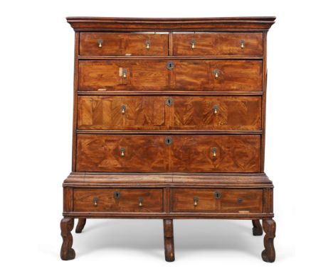 An English walnut and oak feather banded chest on stand, first quarter 18th century and later, two short and three long gradu