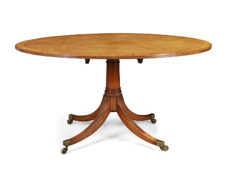 A Regency mahogany oval tilt-top table, first quarter 19th century, the crossbanded top on ring turned column to four splayed