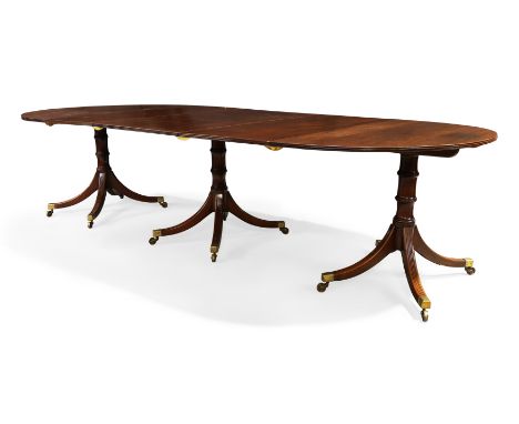 A Regency mahogany triple pedestal D-end dining table, first quarter 19th century, the three pedestals with tilt-tops, on rin