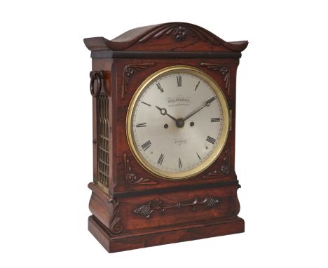 A Victorian rosewood bracket clock, mid-19th century, with shaped top above applied honeysuckle carving, the sides with ring 