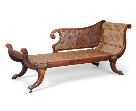 A Regency rosewood chaise longue, first quarter 19th century, with double caned detachable arm, brass eagle mounts and scroll