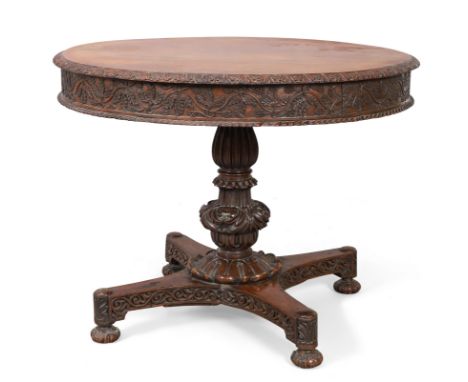 A George IV Anglo-Indian padouk centre table, first quarter 19th century, the circular tilt-top with carved frieze and gadroo