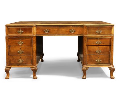 An English walnut inverted breakfront partners desk, Queen Anne style, first quarter 20th century, the top inset with tooled 