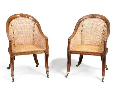 A pair of Regency mahogany library bergere armchairs, in the manner of Gillows, first quarter 19th century, the arched top ra