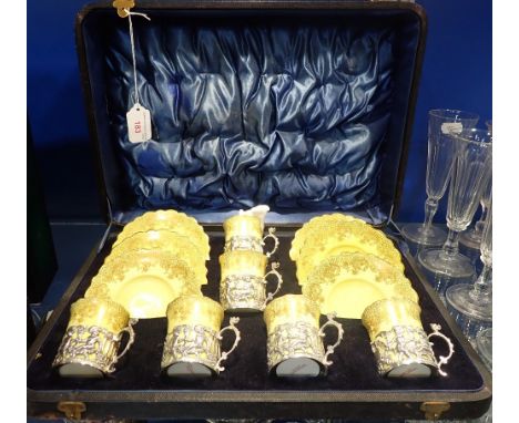 A SET OF SIX J AYNSLEY &amp; SONS COFFEE CANS and saucers with silver holders decorated with cherubs, in a fitted case (note 