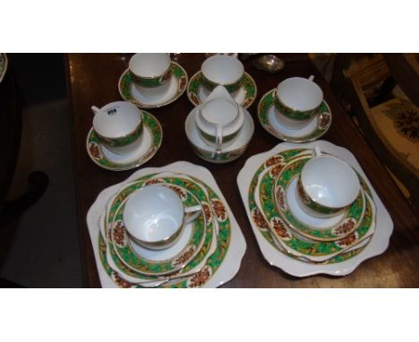 Twenty Two Piece Bone China Tea Set, the large cups are bordered with a deep green decoration, also includes two tea cake pla