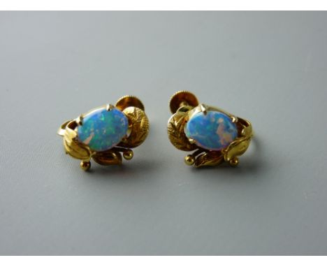 A PAIR OF FOURTEEN CARAT GOLD OPAL SET STUD EARRINGS, each having an oval cabochon opal, 8.7 x 6.5 mm across approximately, t