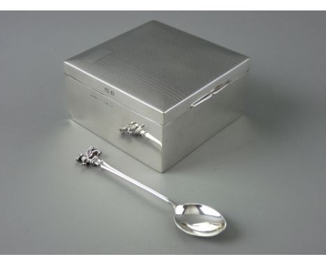 A SQUARE LIDDED CIGARETTE BOX with engine turned decoration, Birmingham 1933 and a silver collector's spoon with Welsh dragon