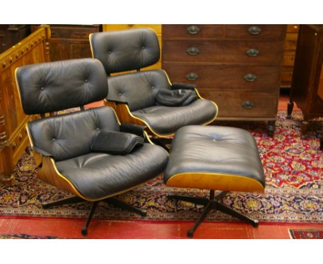 A CHARLES & RAY EAMES STYLE SUITE OF TWO ARMCHAIRS AND A FOOTSTOOL, an iconic style set in shaped and veneer ply and black le