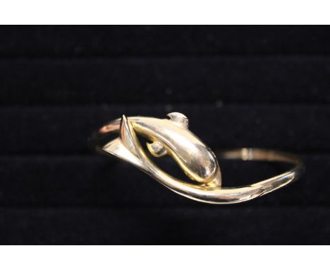 A solid 14ct gold bangle in the form of a dolphin. 12.30 grams. 