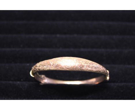 A 9ct gold bangle with safety chain. 7.59 grams 