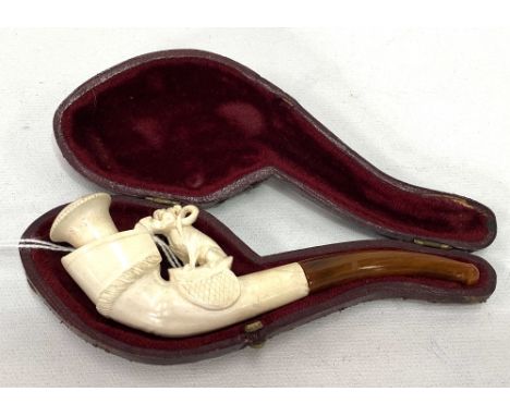 A Meerschaum pipe with ivory mouthpiece, the bowl carved as a dog and horse hoof, within fitted red Moroccan leather case, le