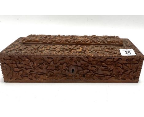 An Indian carved teak rectangular hinge lidded stationery box, with caddy top, the whole profusely carved with animals and bi