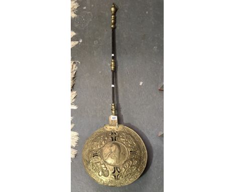 Antique brass and steel handled bedwarming pan, the pan embossed with a central circular portrait surrounded by foliate scrol