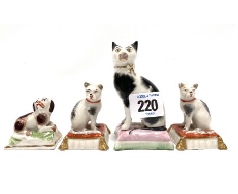 A pair of porcelain cat on cushion groups, gold anchor mark to the base; together with another 19th century cat on cushion fi