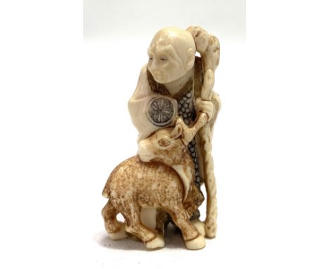 A Japanese Meiji period ivory netsuke carved as a sage with beer, signed, height 6cm.