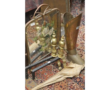 A pair of brass fire dogs, brass umbrella stand and firescreen