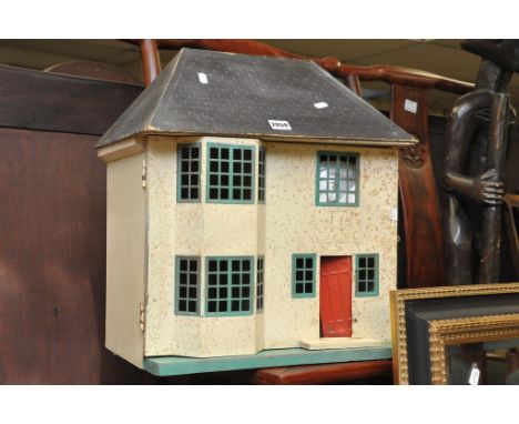 A vintage 1950's dolls house with some furniture