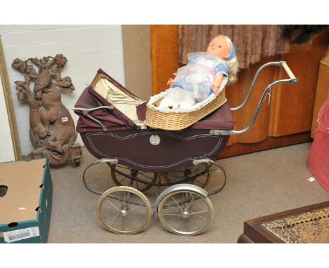 A vintage child's dolls pram and a doll