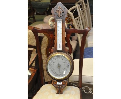 An oak banjo shaped aneroid barometer with silvered dial and applied thermometer box
