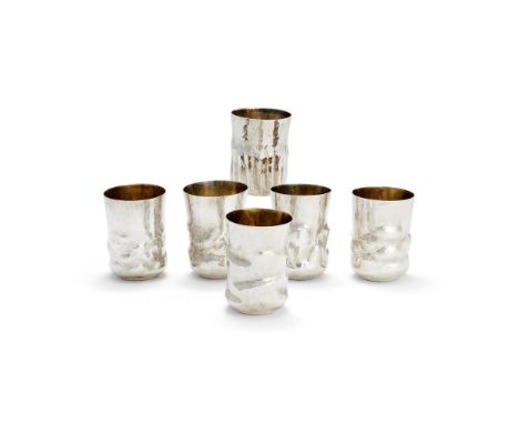 A SET OF SIX DANISH HAMMERED SILVER COLOURED 10.4 CUPS OR BEAKERS CLAUS BJERRING ANDERSEN, 21ST CENTURY With knobbly bases an