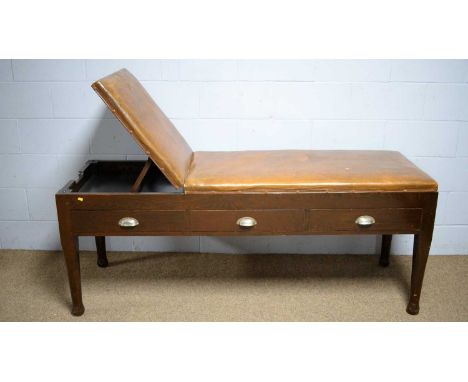 A vintage stained beech examination couch, the leatherette upholstered top with rachet adjusted back support, three drawers b