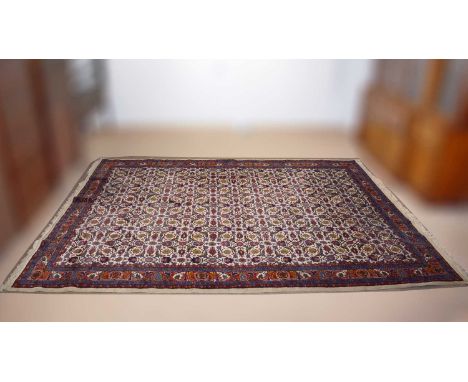 A Saruk carpet, the field of stylised floral motifs within floral borders, on a cream ground, 287 x 385cms.
