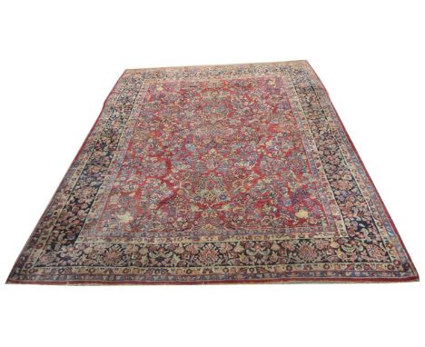 A Mohajeran carpet, with bold floral designs on a red ground, 360 x 278cms.